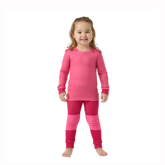 gilrl wearing pink thernal top and bottoms on a white background