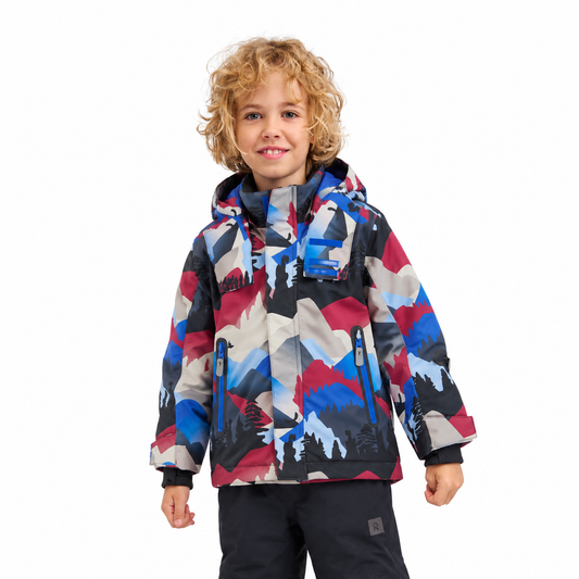 A young child wearing a hooded ski jacket with a colorful mountain camouflage pattern in blue, red, gray, and black, paired with dark ski pants, photographed against a solid white background.