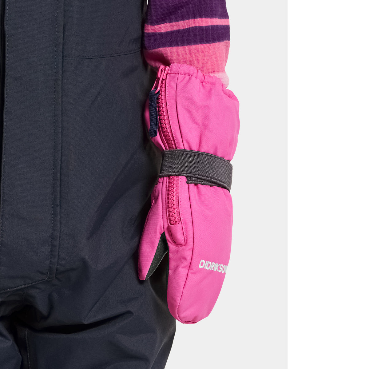 Close-up of pink mittens being put into a dark coat pocket.