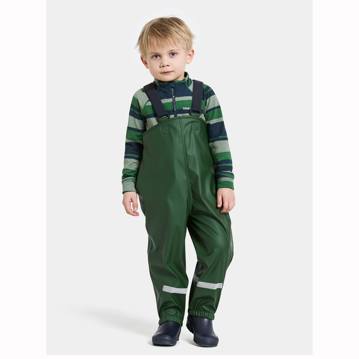 Child wearing green rain pants and a striped shirt on a white background