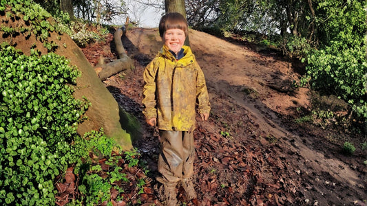 Boy in muddy waterproofs