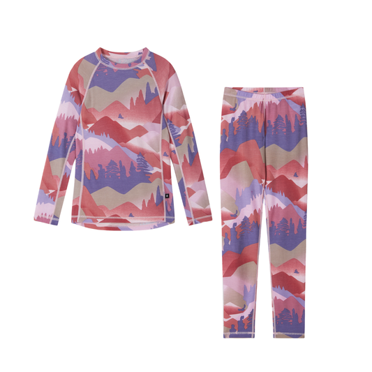 A two-piece children's thermal set featuring a long-sleeve top and matching pants with an all-over scenic mountain and forest pattern in shades of pink, red, purple, and beige, displayed on a clean white background.
