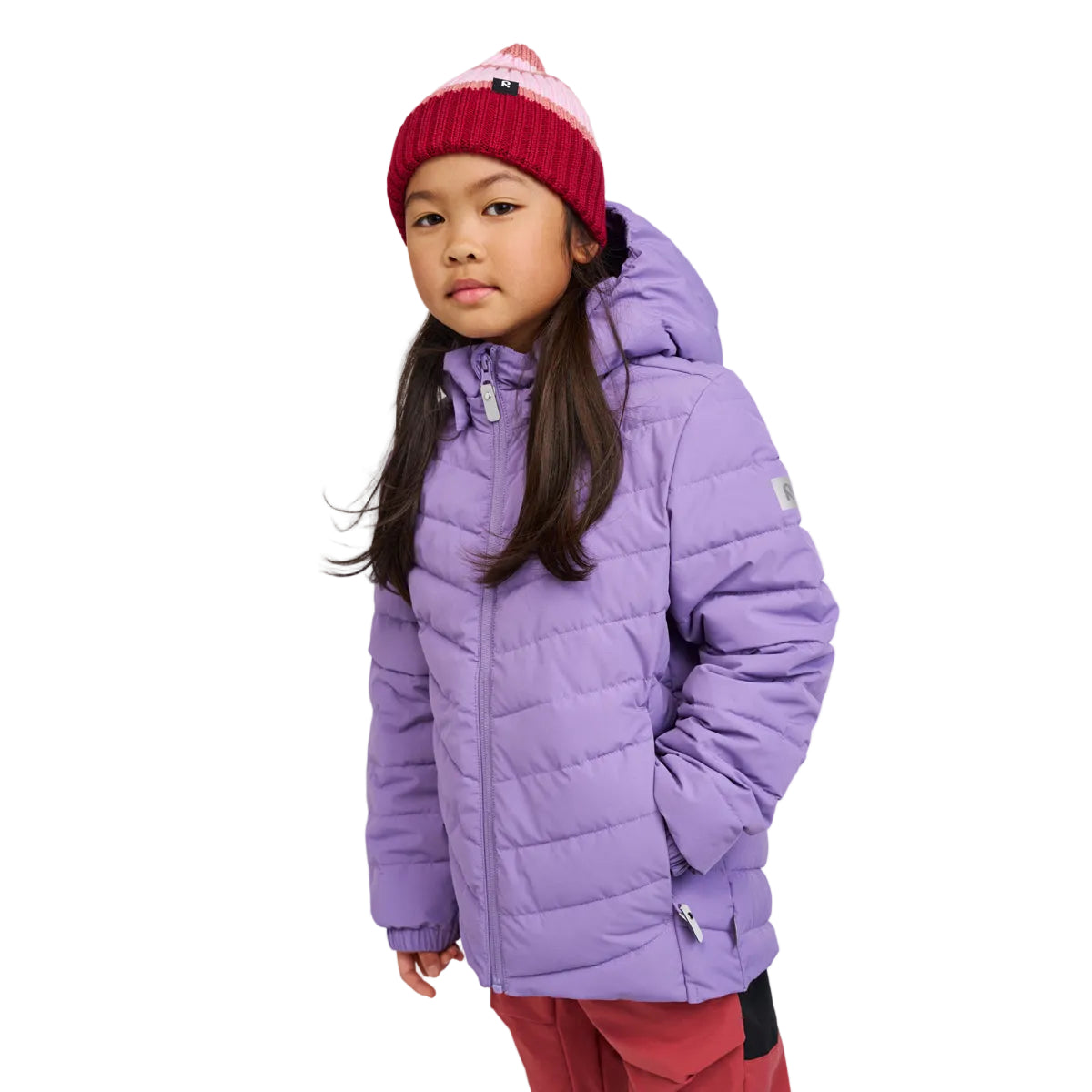 Child wearing a purple jacket and red beanie on a white background