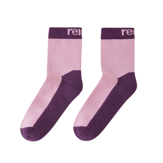 A pair of kids mid-calf socks in light pink and dark purple, featuring a ribbed dark purple cuff with the partial white text 're.