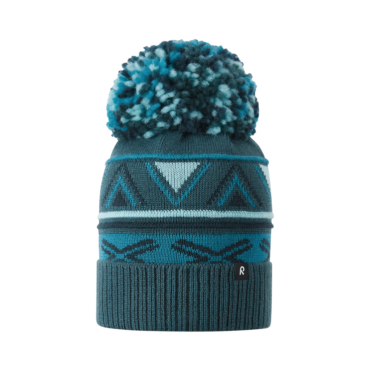 A knit pom-pom beanie hat in dark teal and light blue, featuring geometric patterns and a ribbed cuff with a small black logo.