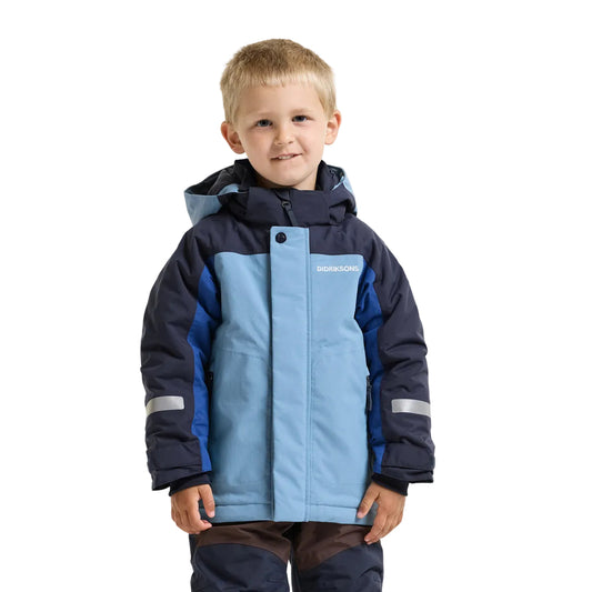 A young boy wearing a hooded winter jacket in light blue and navy blue, with reflective silver stripes on the sleeves, standing against a light gray background.