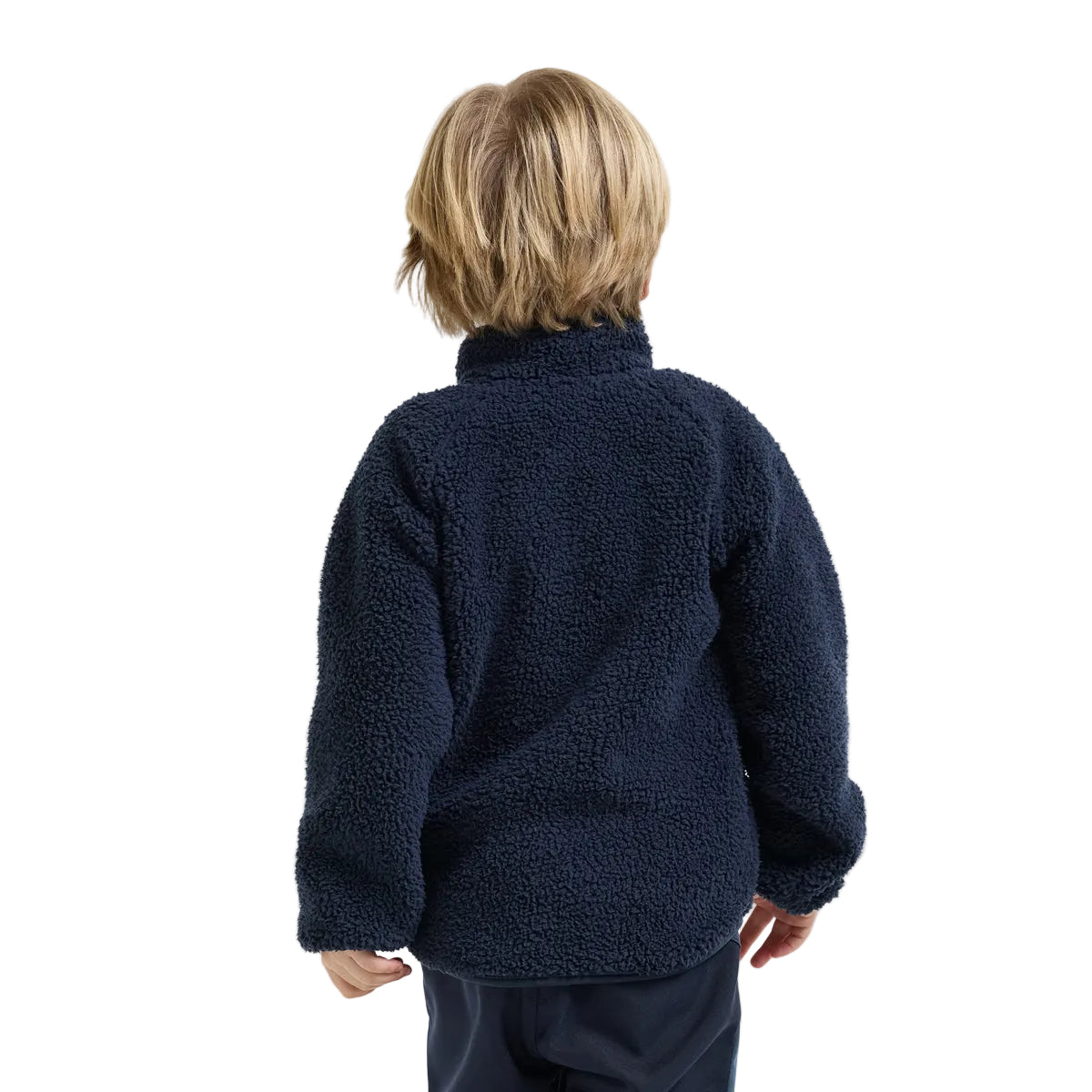 A child viewed from the back wearing a navy blue sherpa fleece jacket and dark pants, set against a plain light gray studio background.