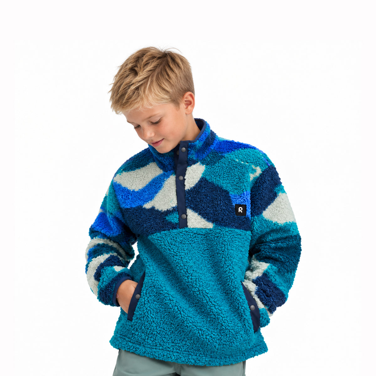 A young boy wearing a blue and teal sherpa fleece quarter-zip pullover with a wavy pattern, photographed against a solid white background.