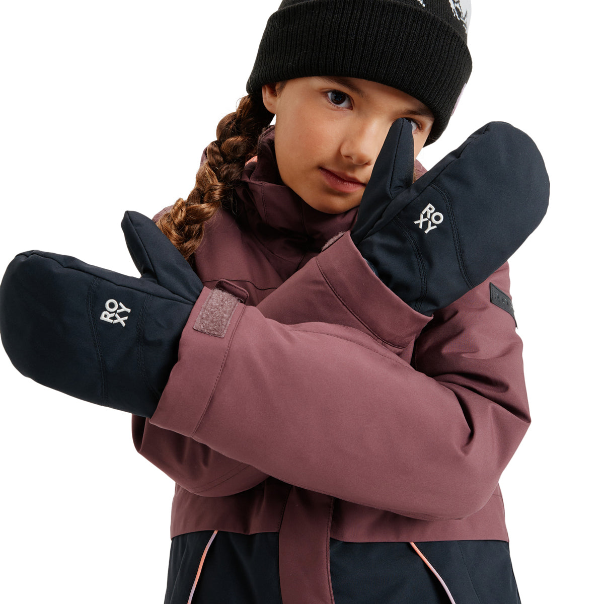 A child wearing a burgundy and black ski jacket, black mittens with white ROY logos, and a black beanie against a solid white background.