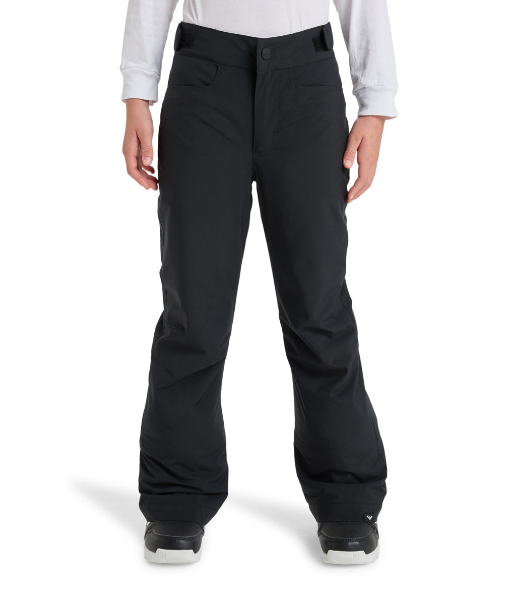 A person wearing black snow pants with a white long-sleeve top and black-and-white sneakers, shown from the waist down against a plain white studio background.
