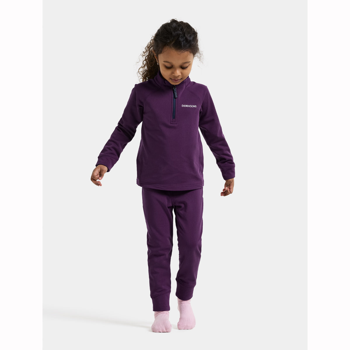 Child wearing a purple thermal set on a white background