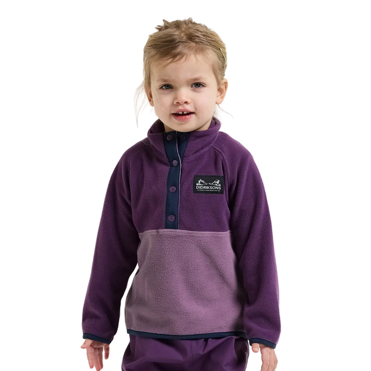 A young child wearing a purple fleece pullover with a darker navy button placket and a matching purple fleece jacket, photographed against a light gray background.